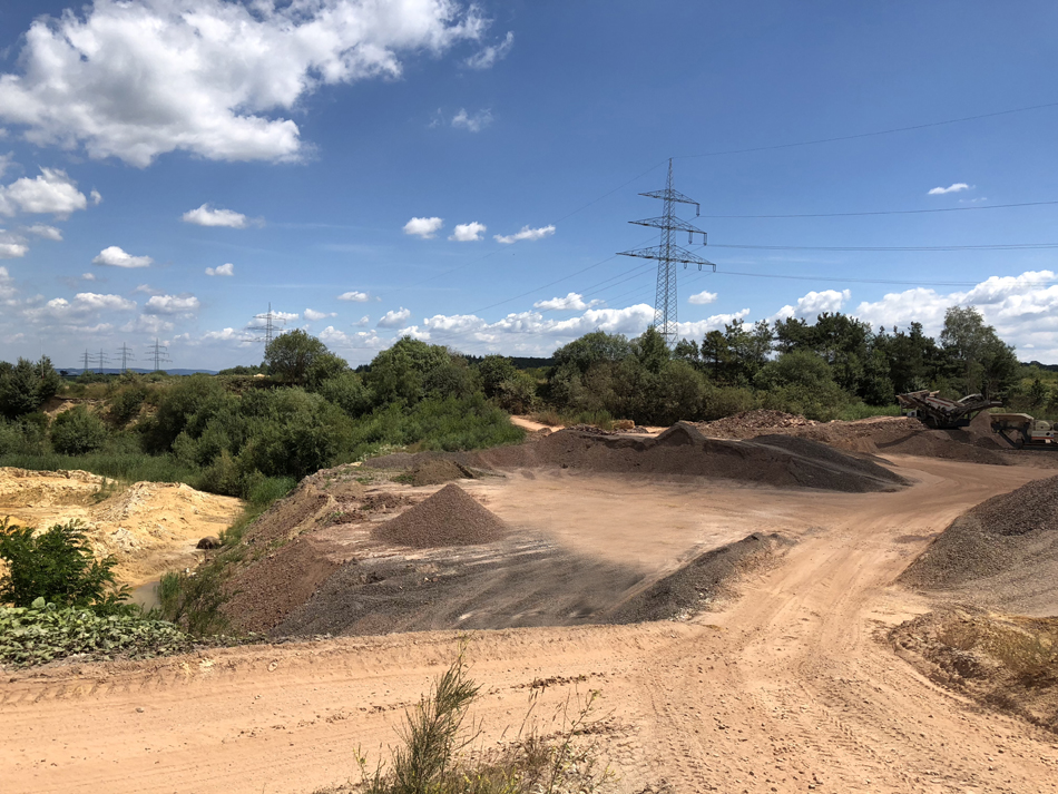 Sandhalde im Werk der Mick Kies GmbH unter blauem Himmel